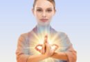 Acharya Sushma Kumari demonstrating Abhaya Hrdaya Mudra with crossed wrists and interlocked fingers for courage